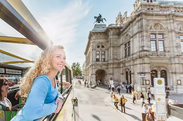 CATch the City Frau bewundert die Wiener Staatsoper aus einem Doppeldeckerbus